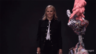 A Woman In A Black Jacket Is Standing In Front Of A Sculpture With The Words Gettyimages On The Bottom Right GIF