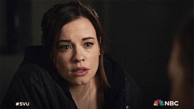 A Woman In A Black Jacket With The Nbc Logo Behind Her GIF