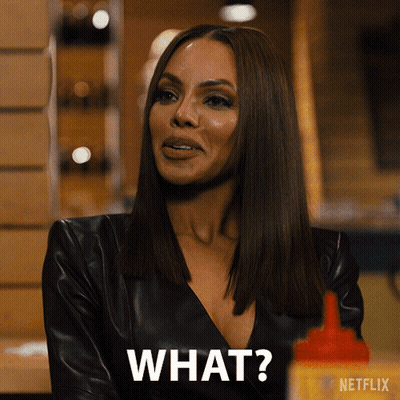 A Woman In A Black Leather Jacket Is Asking " What " GIF