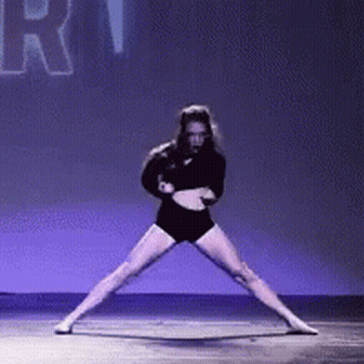 A Woman In A Black Outfit Is Dancing On A Stage With The Word Rhythm In The Background . GIF