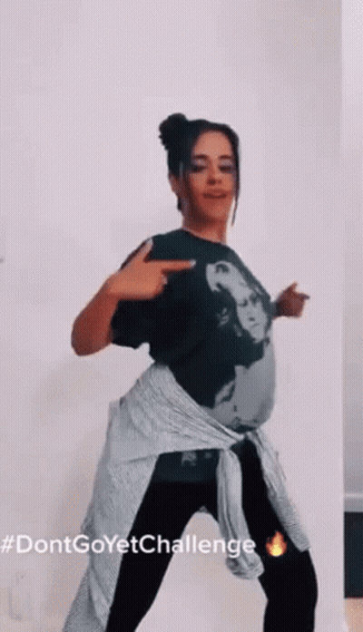 A Woman In A Black Shirt And Black Pants Is Dancing . GIF