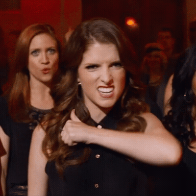 A Woman In A Black Shirt Is Making A Funny Face With Her Fist GIF