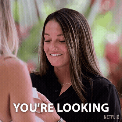 A Woman In A Black Shirt Is Smiling And Says You 'Re Looking GIF