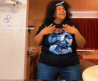 A Woman In A Black Shirt Is Standing In A Room . GIF