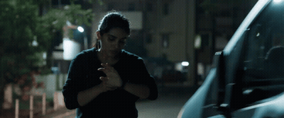 A Woman In A Black Shirt Is Standing Next To A Van GIF