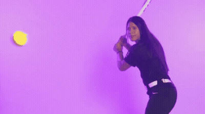 A Woman In A Black Shirt Is Throwing Confetti In The Air Against A Purple Background GIF