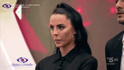 A Woman In A Black Shirt Stands In Front Of A Sign That Says 5 Hd GIF