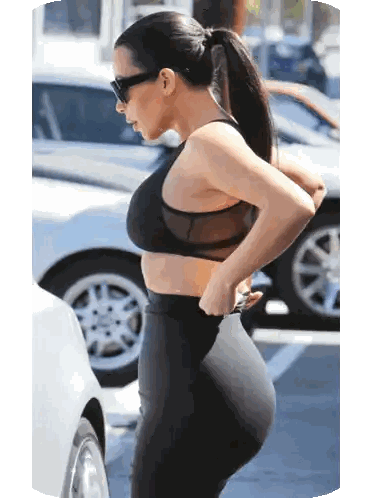 A Woman In A Black Sports Bra And Black Leggings Stands In A Parking Lot Sticker