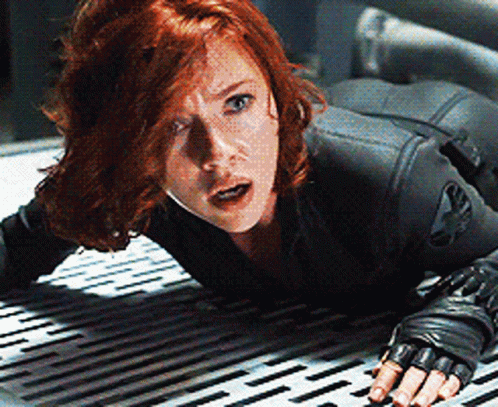 A Woman In A Black Suit Is Crawling On A Metal Floor . GIF