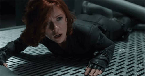 A Woman In A Black Suit Is Laying On The Floor GIF