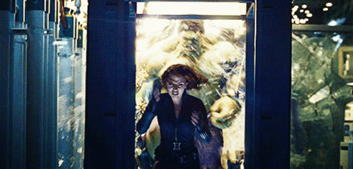 A Woman In A Black Suit With The Letter I On Her Belt GIF