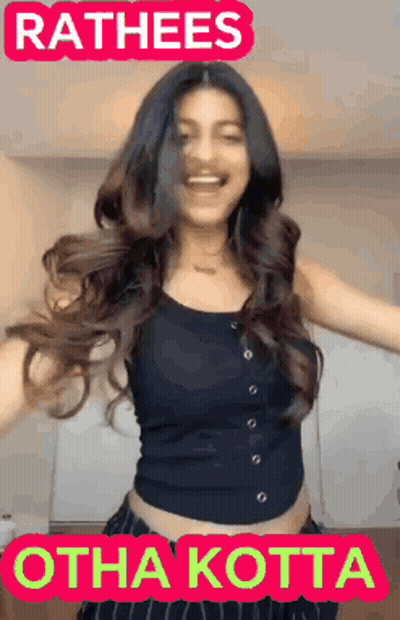 A Woman In A Black Tank Top Is Dancing With The Words Rathees Othakotta Written Above Her GIF