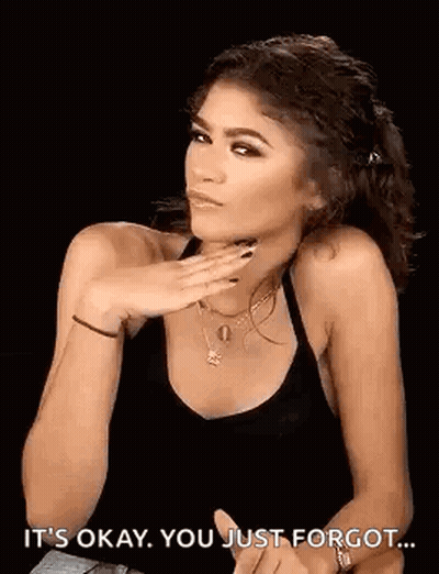 A Woman In A Black Tank Top Is Making A Funny Face While Holding Her Hand To Her Face . GIF