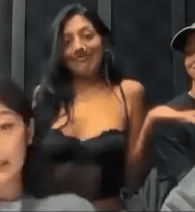 A Woman In A Black Tank Top Is Sitting Next To A Man In A Hat . GIF