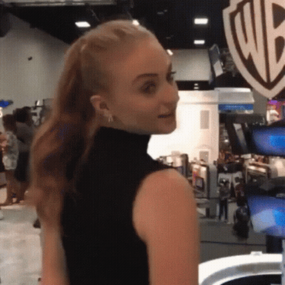 A Woman In A Black Tank Top Is Standing In Front Of A Wb Logo GIF