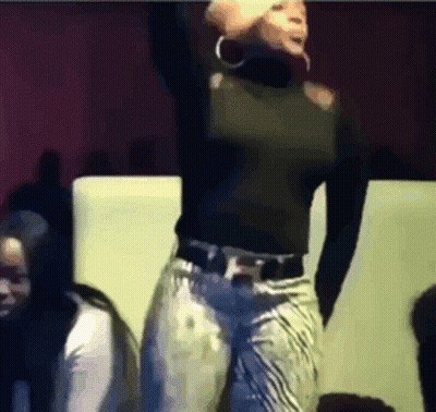 A Woman In A Black Top And Jeans Is Dancing GIF