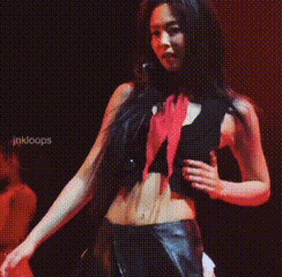 A Woman In A Black Top And Red Scarf Is Standing In Front Of A Sign That Says Jakloops GIF