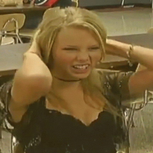 A Woman In A Black Top Holds Her Hair In Her Hands GIF