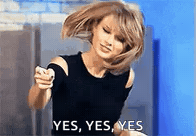 A Woman In A Black Top Is Pointing At The Camera And Saying Yes . GIF