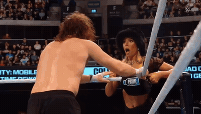 A Woman In A Black Top With The Word Prime On It Is Wrestling A Man In A Ring GIF