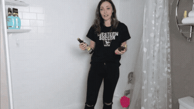 A Woman In A Black Western Soccer Shirt Holds A Bottle GIF
