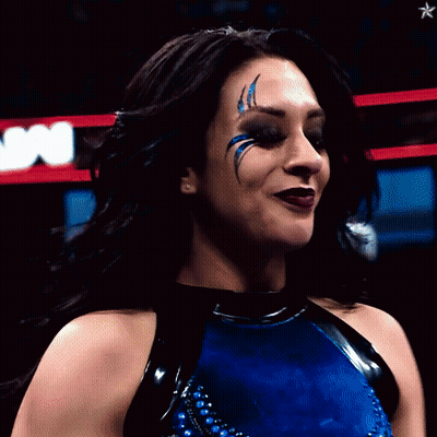 A Woman In A Blue And Black Outfit With A Star In The Background GIF
