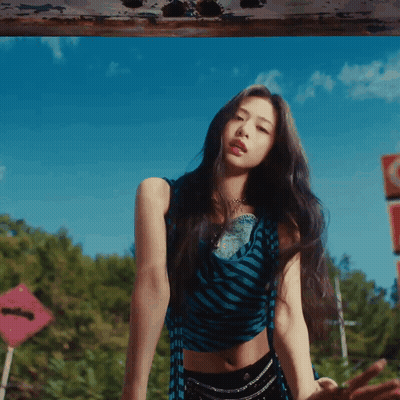 A Woman In A Blue And Black Striped Crop Top And Black Shorts GIF
