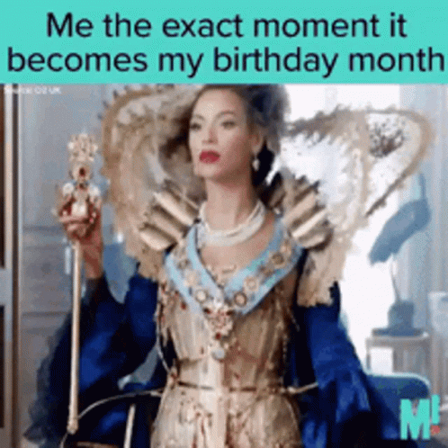 A Woman In A Blue And Gold Dress Is Holding A Crown GIF