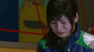 A Woman In A Blue And Green Leather Jacket Is Crying GIF