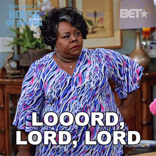 A Woman In A Blue And Pink Zebra Print Dress Is Standing In A Living Room And Says Looord Lord Lord GIF