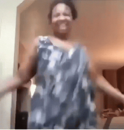 A Woman In A Blue And White Dress Is Dancing In A Room . GIF