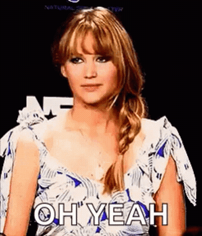 A Woman In A Blue And White Dress Is Making A Funny Face . GIF