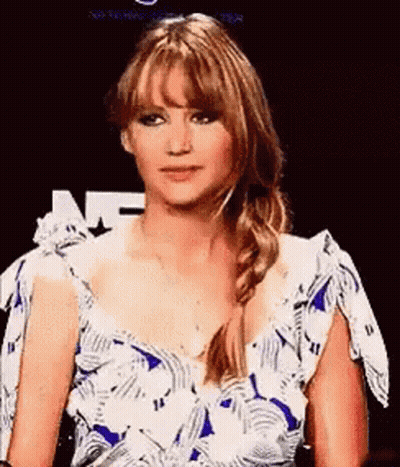 A Woman In A Blue And White Dress With A Braid Is Making A Funny Face . GIF
