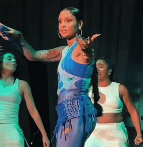 A Woman In A Blue And White Outfit Is Dancing On Stage GIF