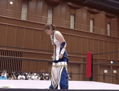 A Woman In A Blue And White Outfit Is Standing On A Ring GIF