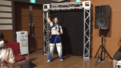 A Woman In A Blue And White Outfit Stands In A Room GIF