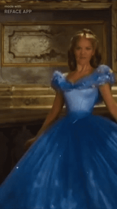 A Woman In A Blue Ball Gown Is Standing In A Room GIF