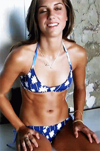 A Woman In A Blue Bikini With White Flowers On It Smiles GIF
