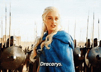 A Woman In A Blue Cape Is Standing In Front Of A Group Of Soldiers And Says " Dracarys " GIF