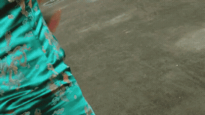 A Woman In A Blue Cheongsam Holds A Sword GIF