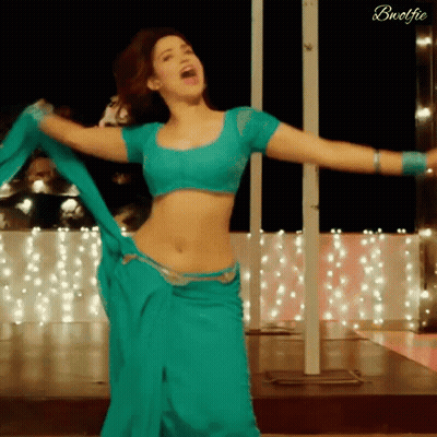 A Woman In A Blue Crop Top And A Blue Skirt Is Dancing GIF