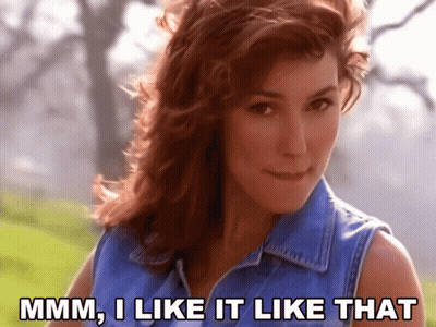 A Woman In A Blue Denim Vest Says " Mmm I Like It Like That " GIF