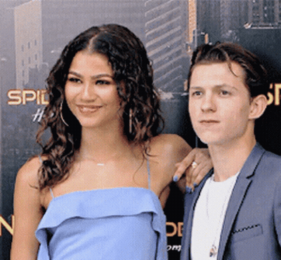 A Woman In A Blue Dress And A Man In A Suit Are Posing For A Picture GIF