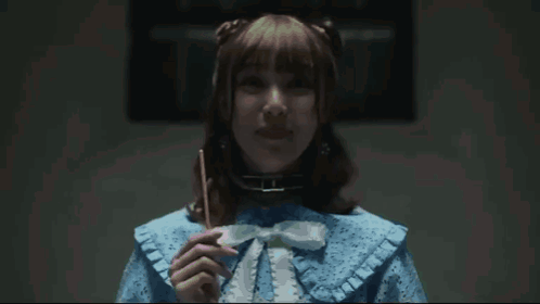 A Woman In A Blue Dress Has Her Finger On Her Lips GIF