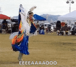 A Woman In A Blue Dress Is Dancing In A Field With A Caption That Says Eeeaaaooo . GIF