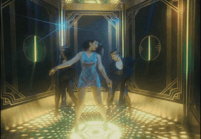A Woman In A Blue Dress Is Dancing On A Stage GIF