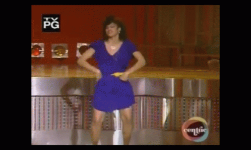A Woman In A Blue Dress Is Dancing On A Stage With A Tv Pg Logo In The Background . GIF