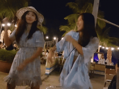 A Woman In A Blue Dress Is Dancing With Another Woman GIF