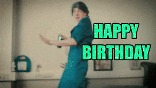 A Woman In A Blue Dress Is Dancing With The Words Happy Birthday Written In Green Letters GIF
