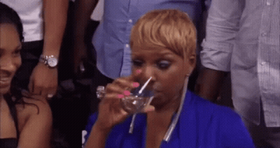 a woman in a blue dress is drinking water from a glass .